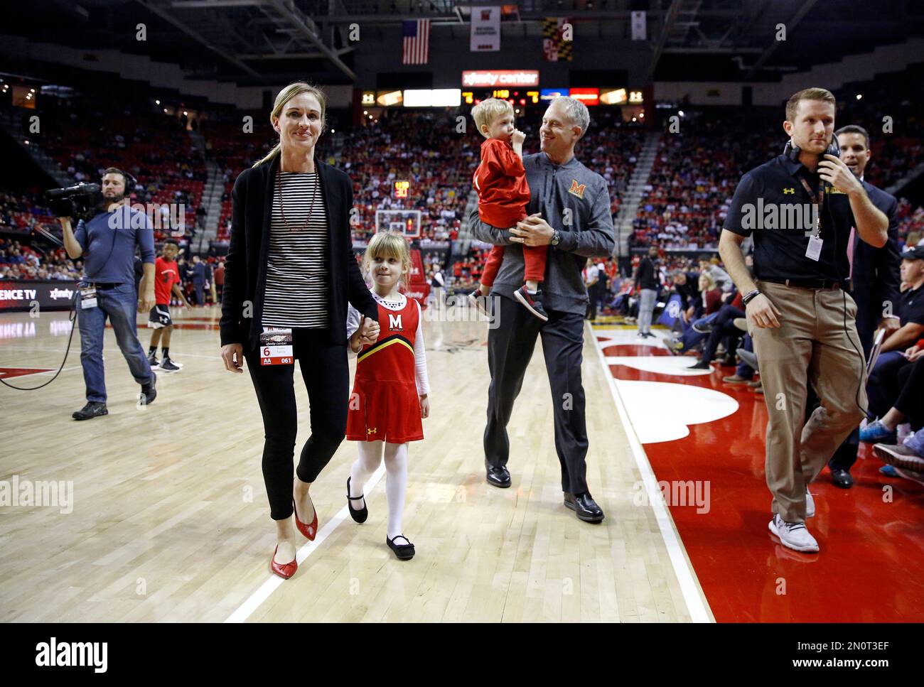 Maryland football head coach D.J. Durkin, second from right, carries his  son Luke off the court after being introduced during a timeout in an NCAA  college basketball game between Maryland and St.