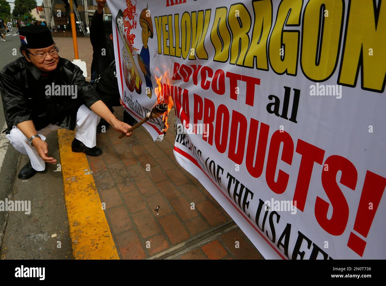 Philippine presidential candidate Elly Pamatong burns a banner urging