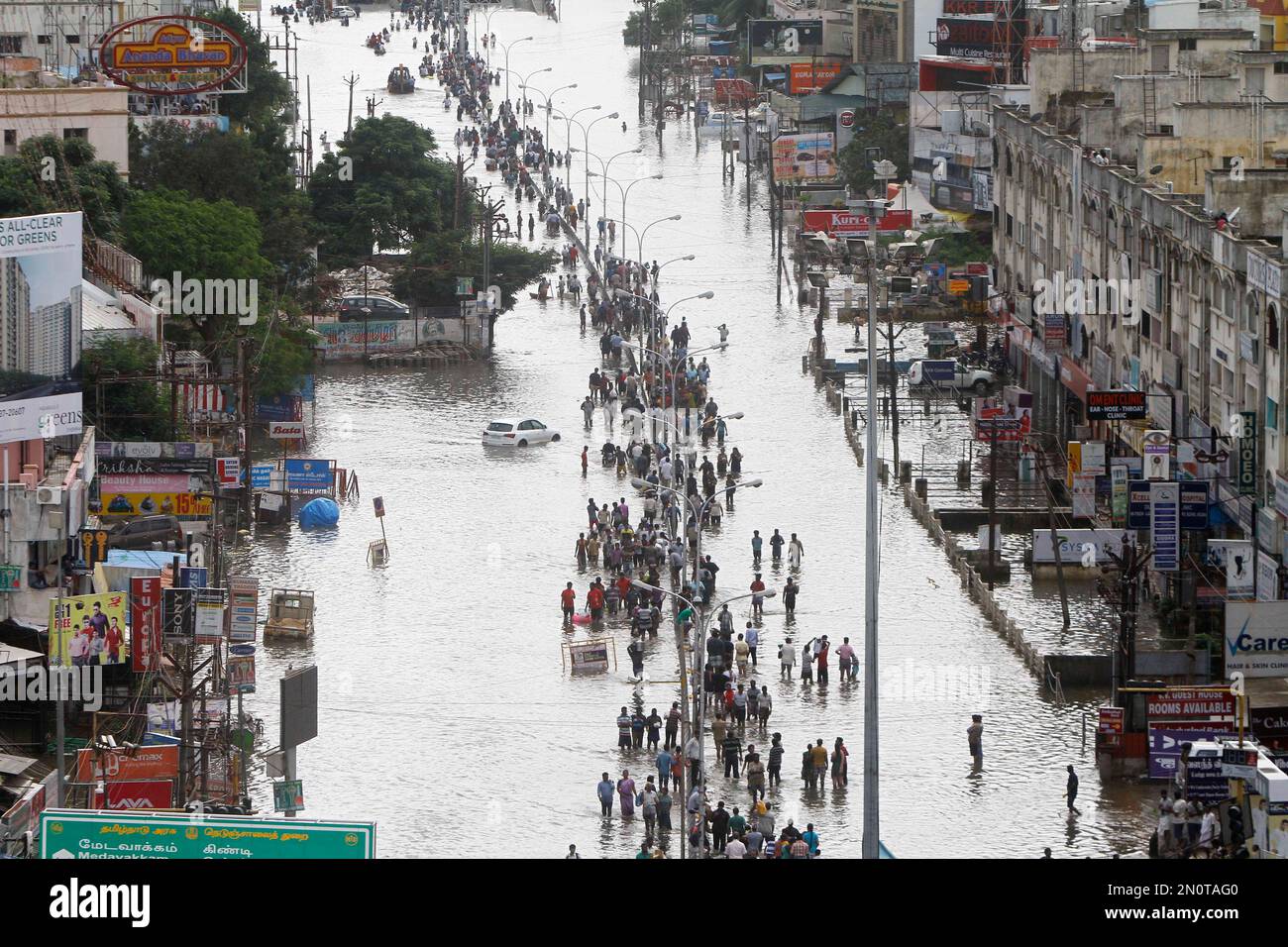 People walk through a flooded street in Chennai, India, Thursday, Dec ...