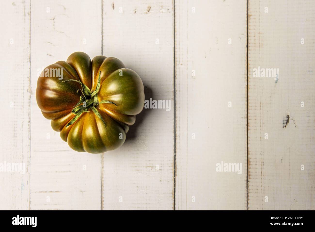 PNG image of a ripe marmande sweet tomato on a white wooden table Stock Photo
