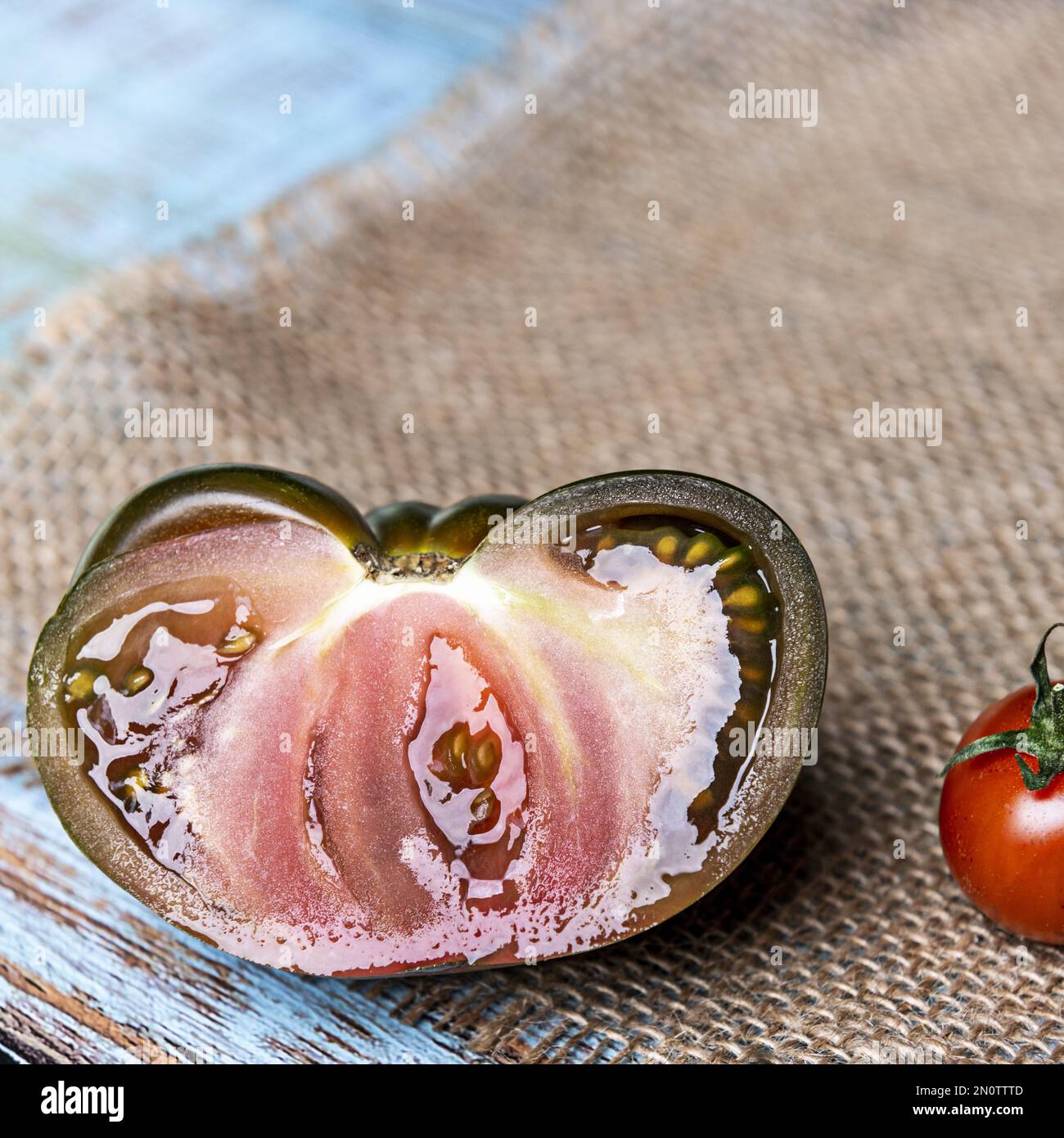 Image of a ripe sweet marmande tomato split in half looking delicious Stock Photo