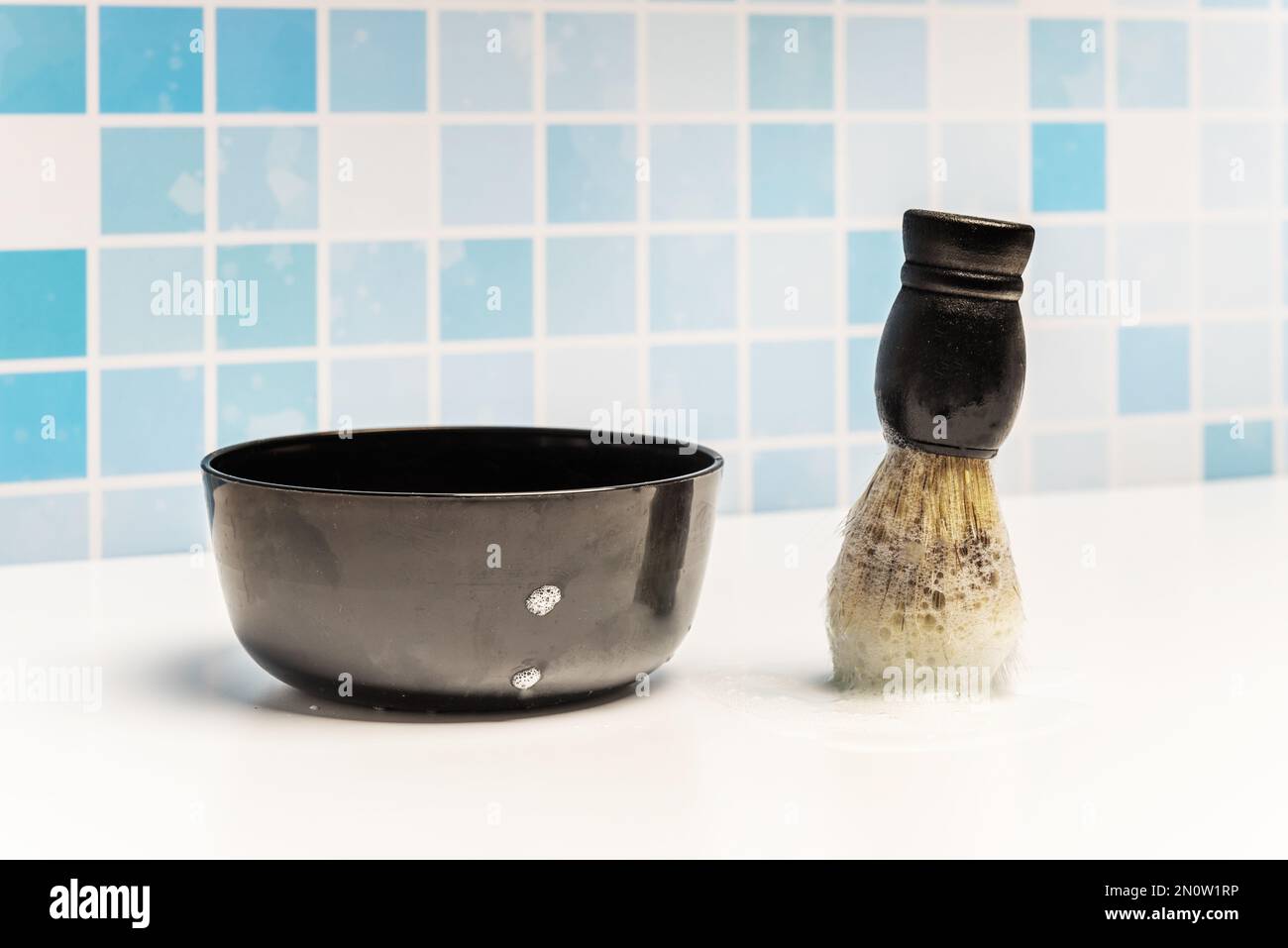 A lathering brush for lathering the face before shaving the face in the