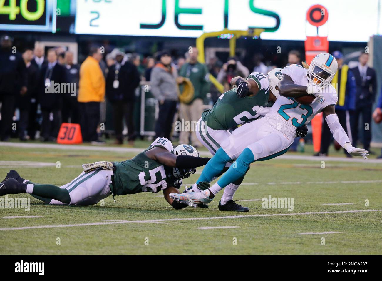 Miami Dolphins running back Jay Ajayi (23) is tackled by New York Jets'  Demario Davis (56) and Marcus Gilchrist (21) during the second half of an  NFL football game Sunday, Nov. 29,