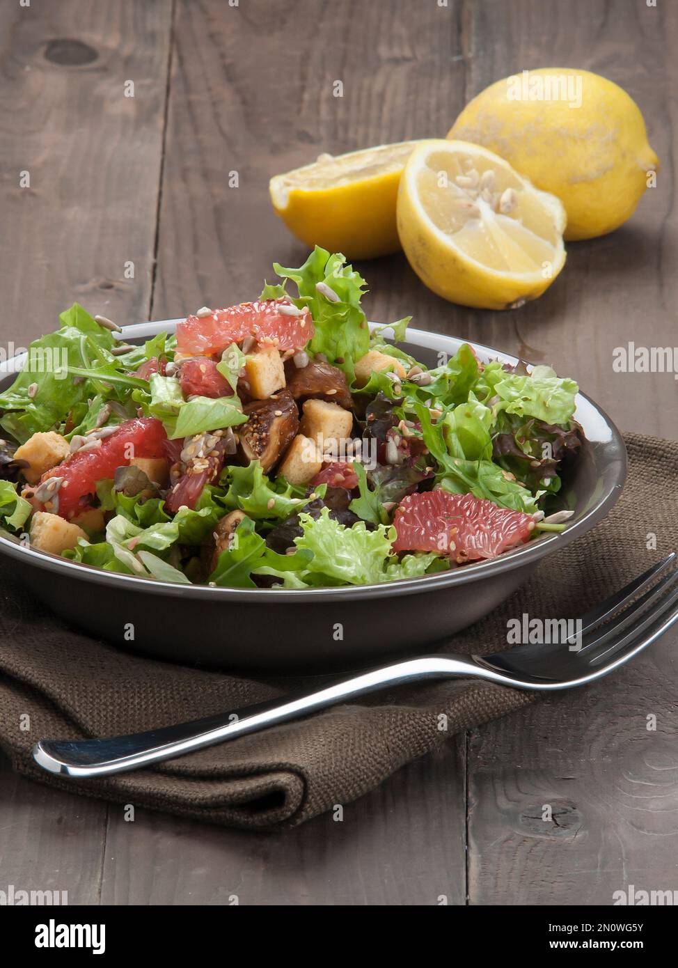 Green salad with baby arugula, citrus fruits, dried figs, croutons, sesame and sunflower seeds. Healthy and light recipes.Vegan. Vegetarian Stock Photo