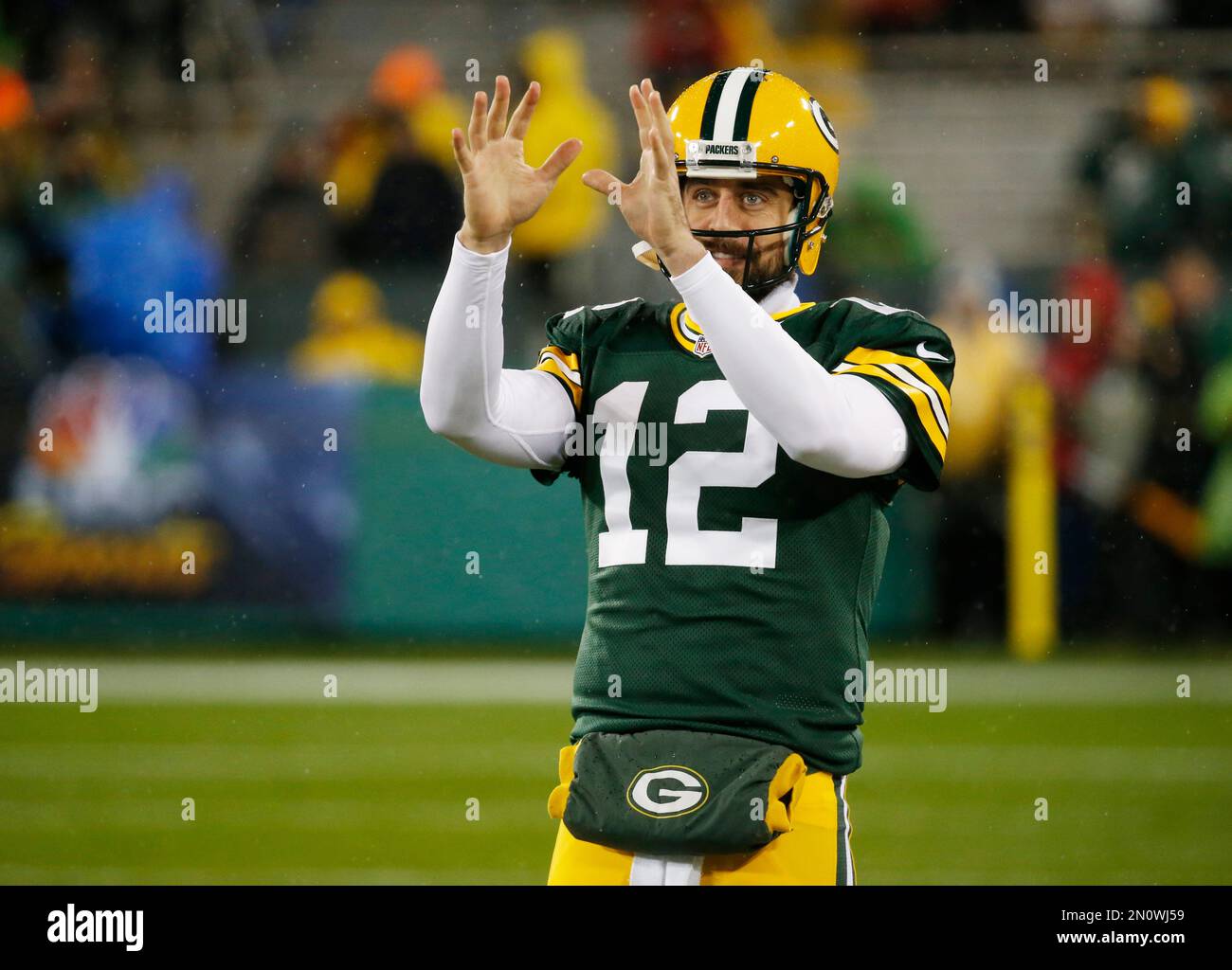 Green Bay Packers' Aaron Rodgers warms up in the rain before an