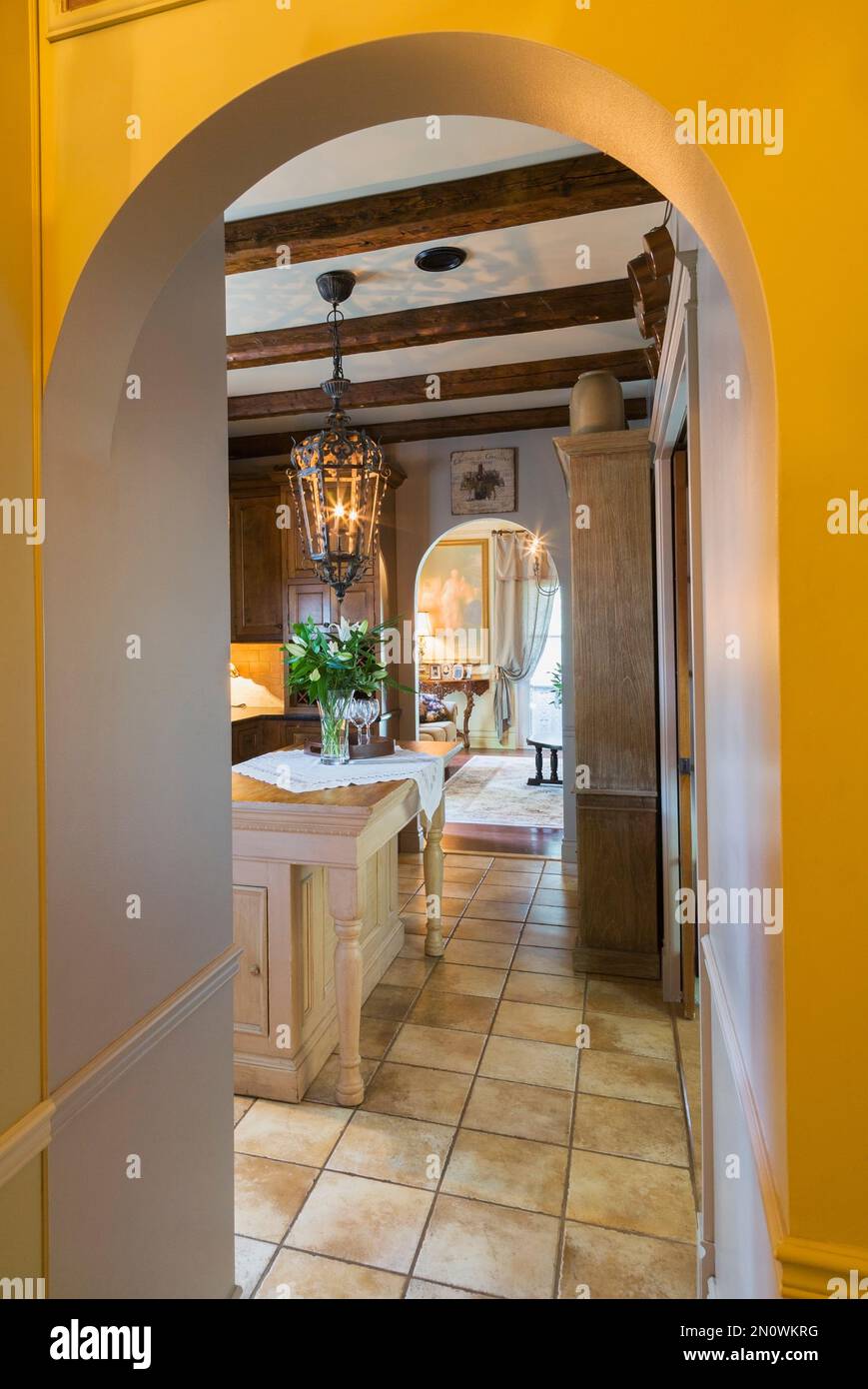 Kitchen with repurposed church altar table as island through arched ...