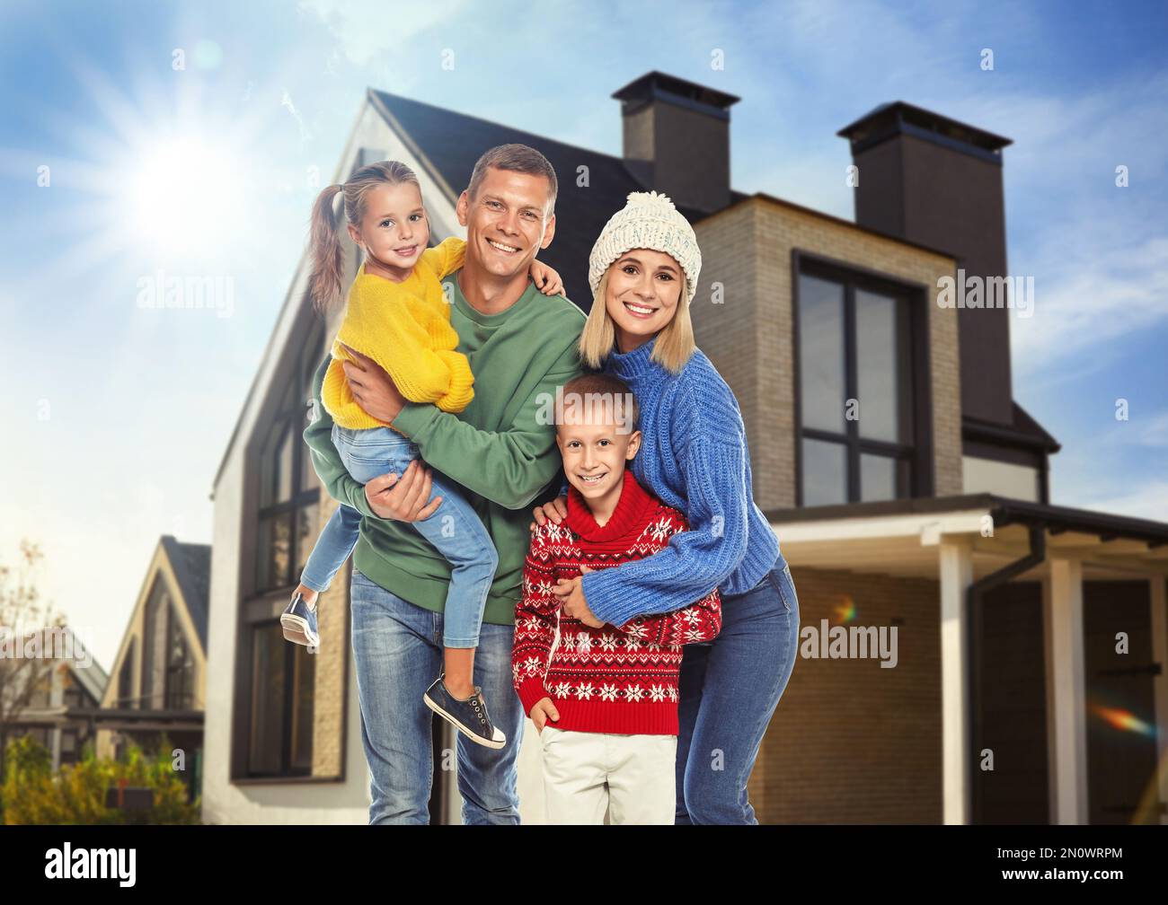 Happy family standing in front of their house on sunny day Stock Photo ...