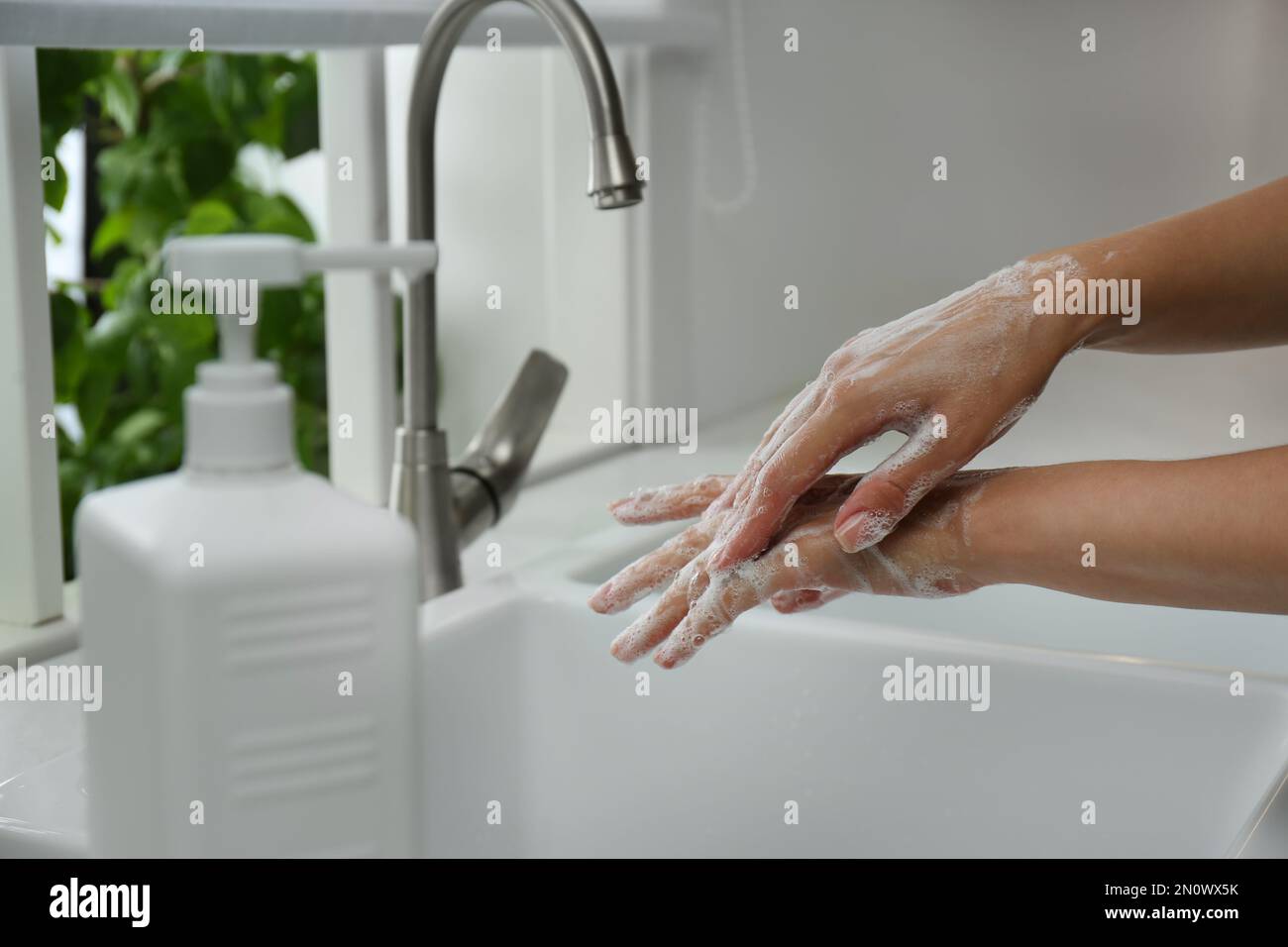 Woman washing hands with antibacterial soap indoors, closeup. Personal ...