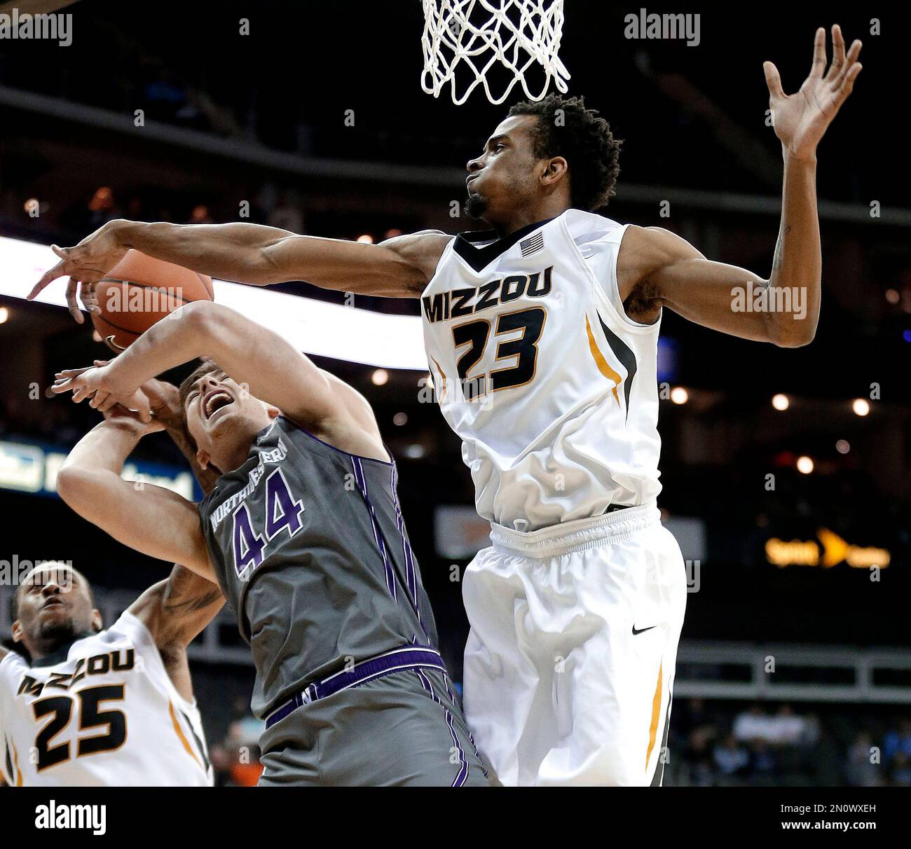 Missouri's Jakeenan Gant (23) and Russell Woods (25) strip the ball from  Northwestern's Gavin Skell (44) during the first half of an NCAA college  basketball game Tuesday, Nov. 24, 2015, in Kansas