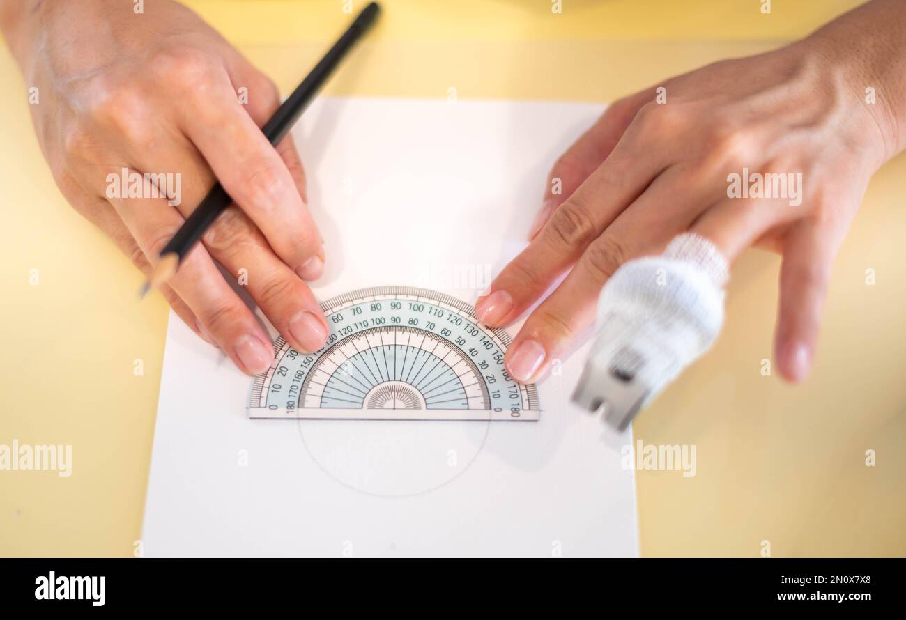 Female hand using a measure circle ruler with a wood pencil preparing