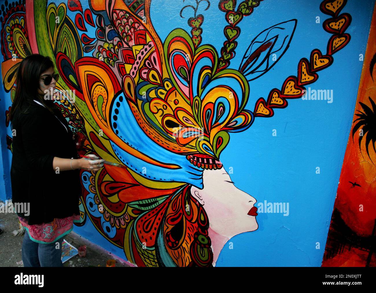 Pakistani students put the final touches to a mural on a wall, during a campaign called Street