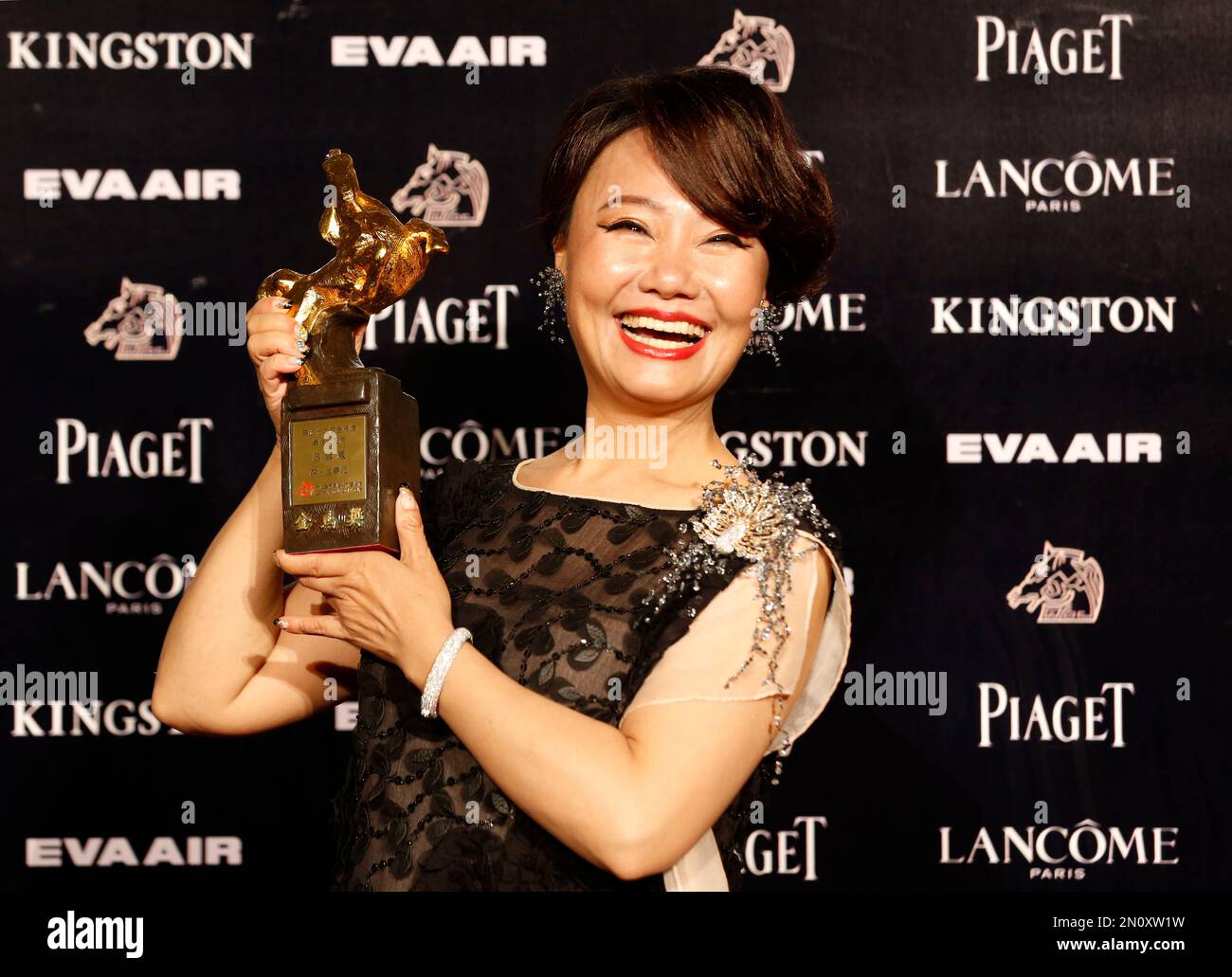Taiwanese actress Lu Xuefeng holds her award for Best Supporting ...