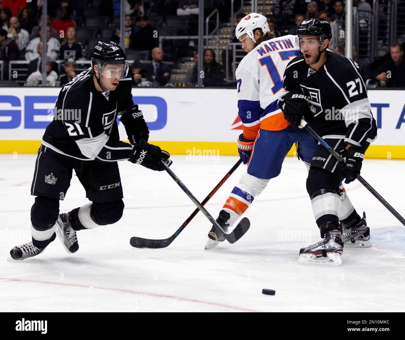 Los Angeles Kings center Nick Shore (21) and defenseman Alec Martinez (27)  clear the puck away from New York Islanders left wing Matt Martin (17)  during the first period of an NHL