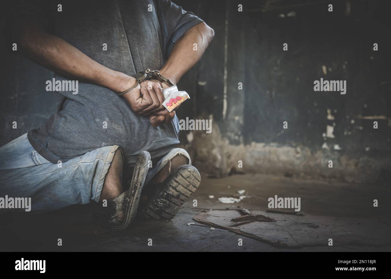 Drug dealer under arrest confined with handcuffs, standing next to a wall.  Law and police concept.  World Anti-drug Day Stock Photo