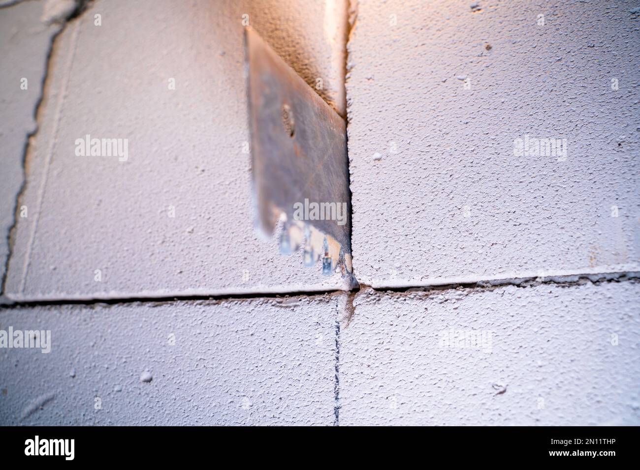A hacksaw for aerated concrete sticks out of a wall of aerated concrete