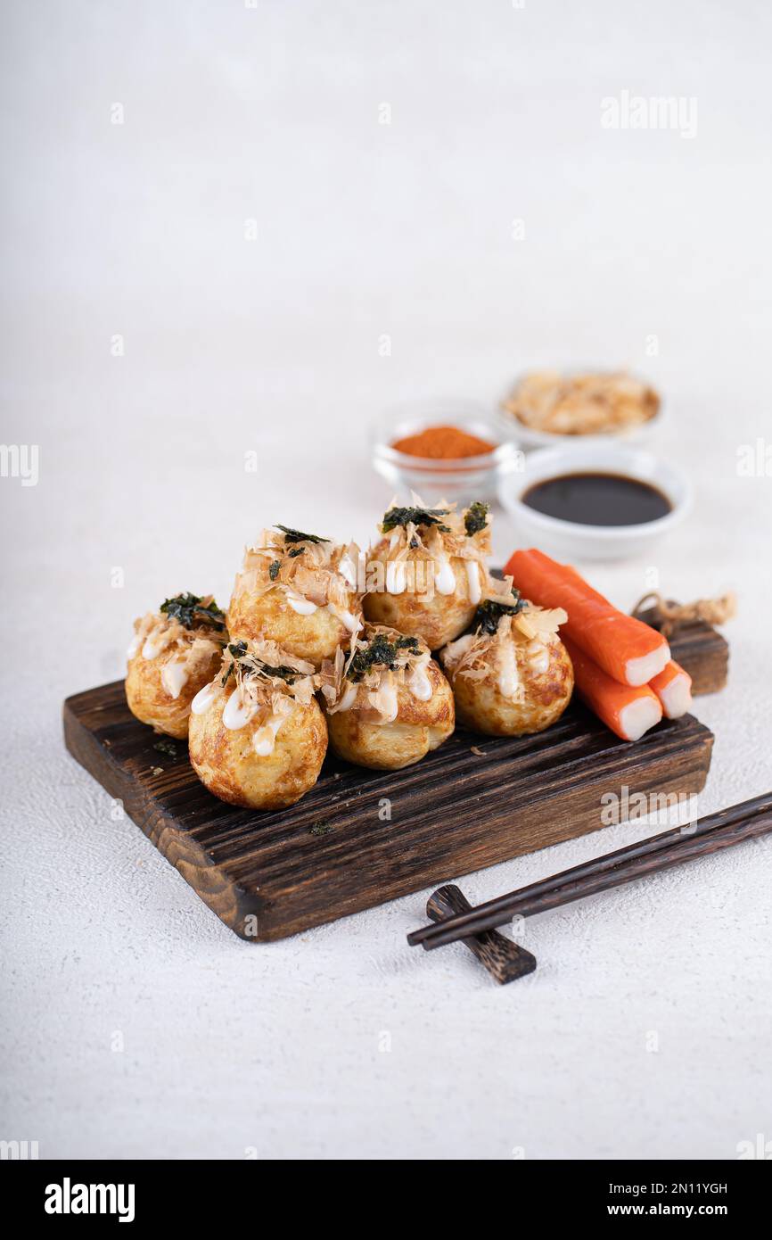 Takoyaki is Japanese Street Food containing with octopus, sausage or cheese. garnish with