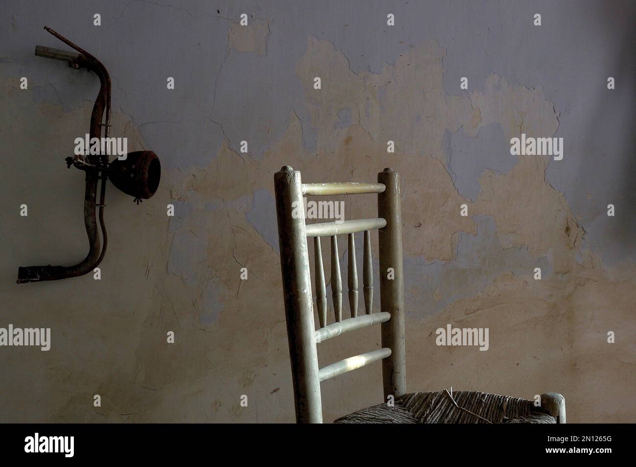 Spanish chair with handlebars from bicycle in front of wall Stock Photo