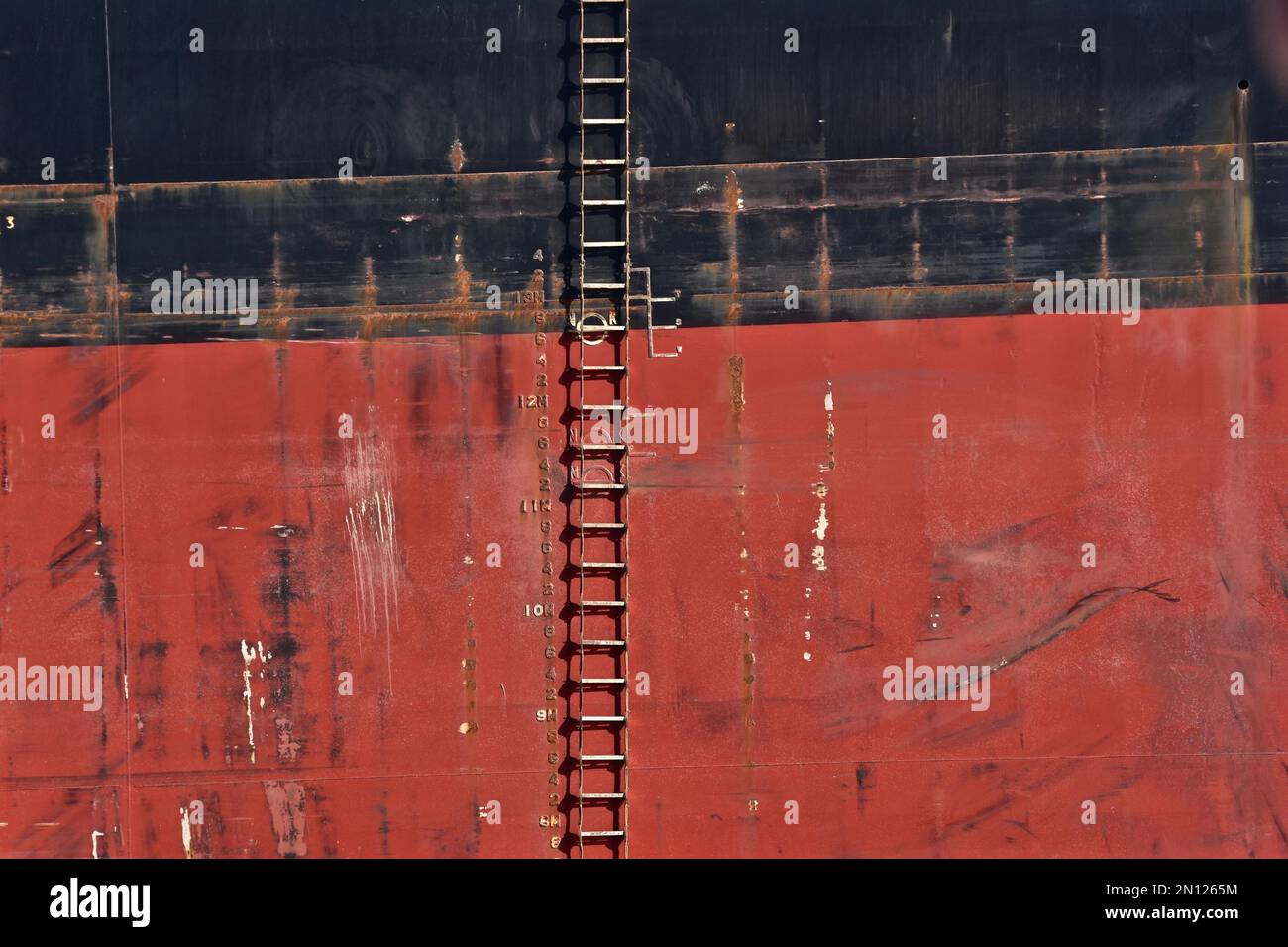 Rope ladder on the red and black side of a freighter Stock Photo