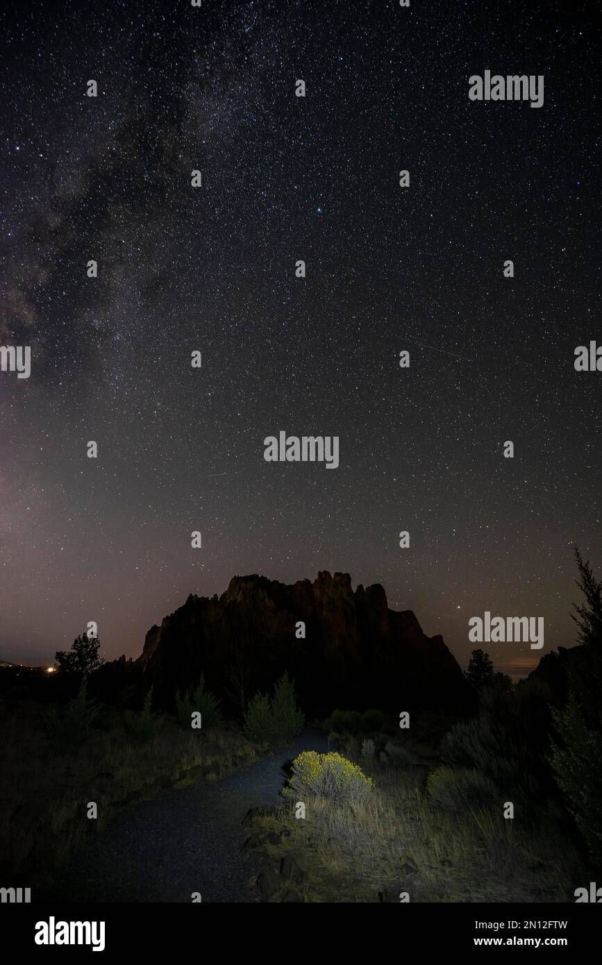 Lighted path and canyon against night sky, starry sky with Milky Way
