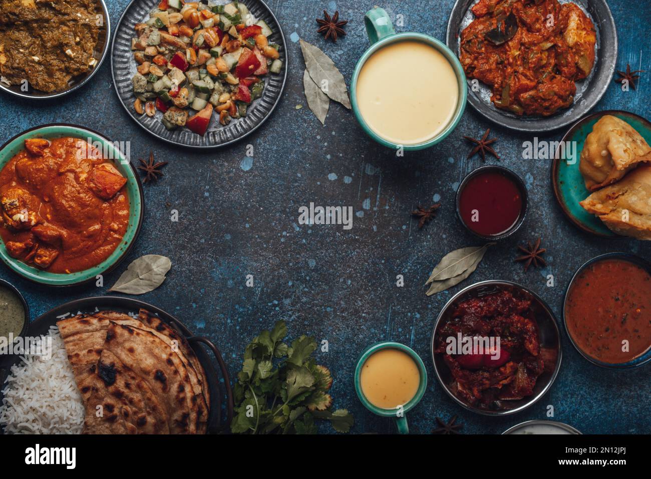 Indian ethnic food buffet on concrete table from above: curry, samosa ...