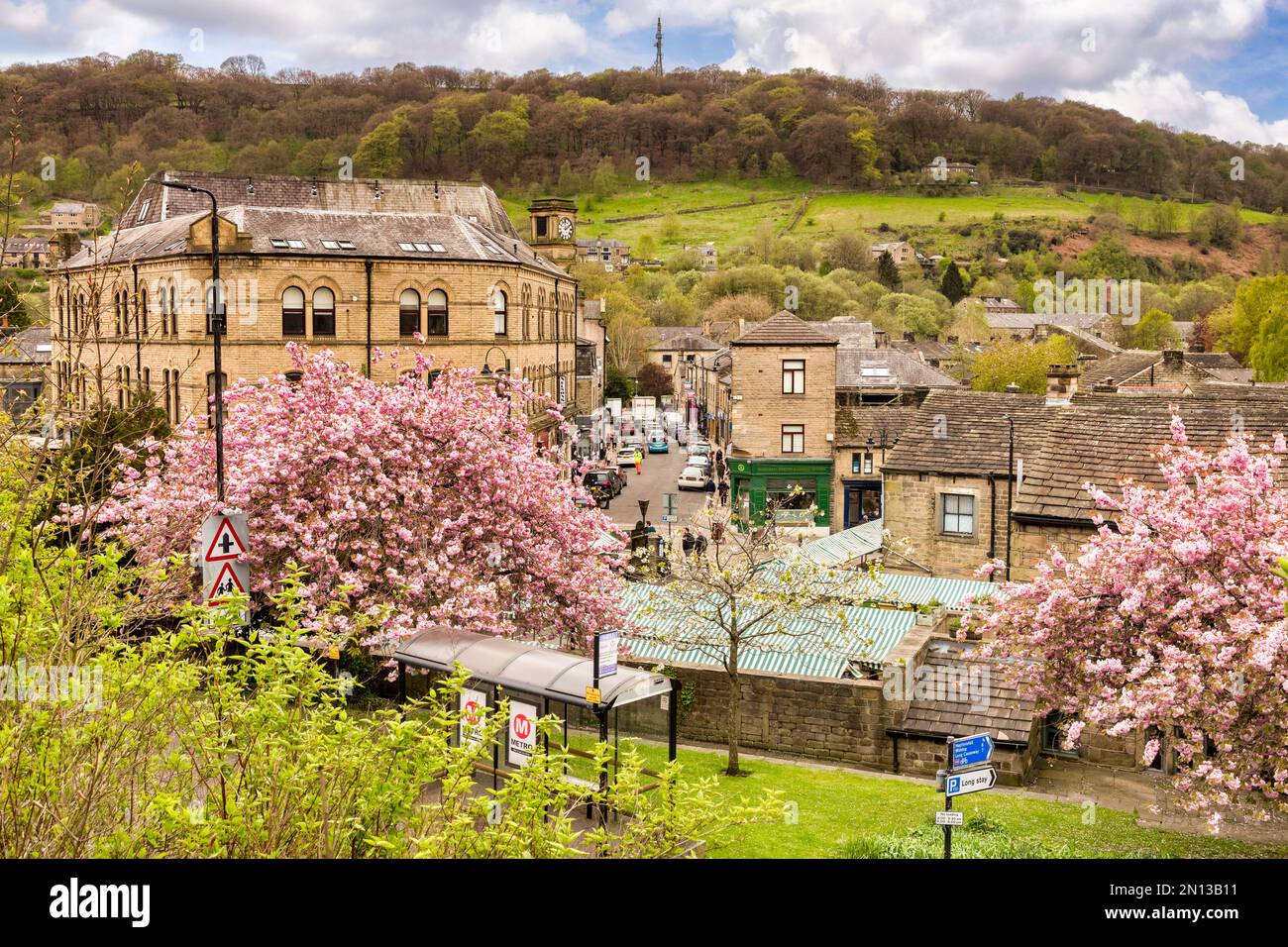 27 April 2022: Hebden Bridge, UK - A view over the beautiful Yorkshire town of Hebden Bridge, with cherry trees and busy Crown Street. Stock Photo