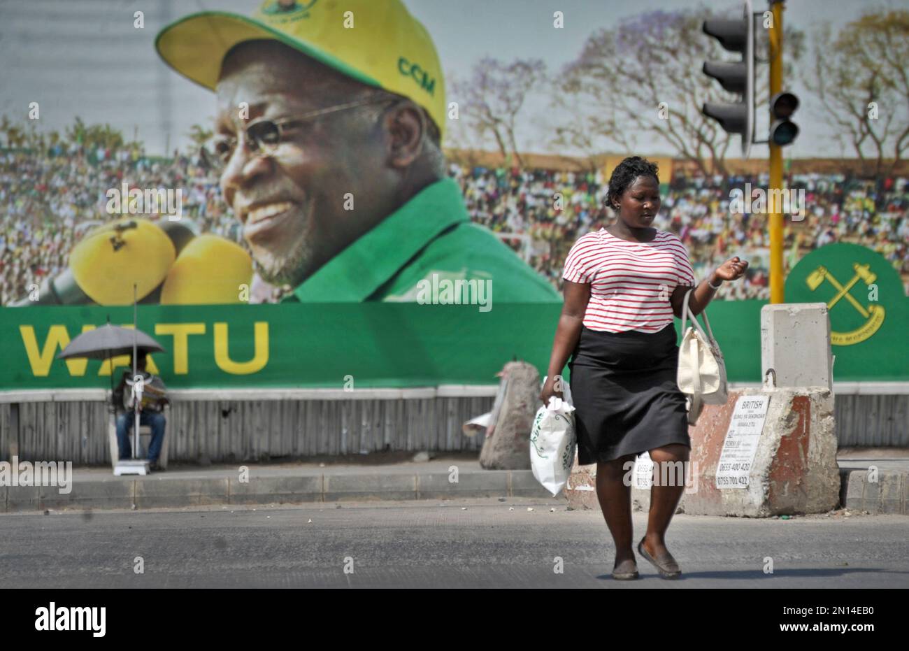 A Tanzanian woman walks past a billboard for the ruling party's
