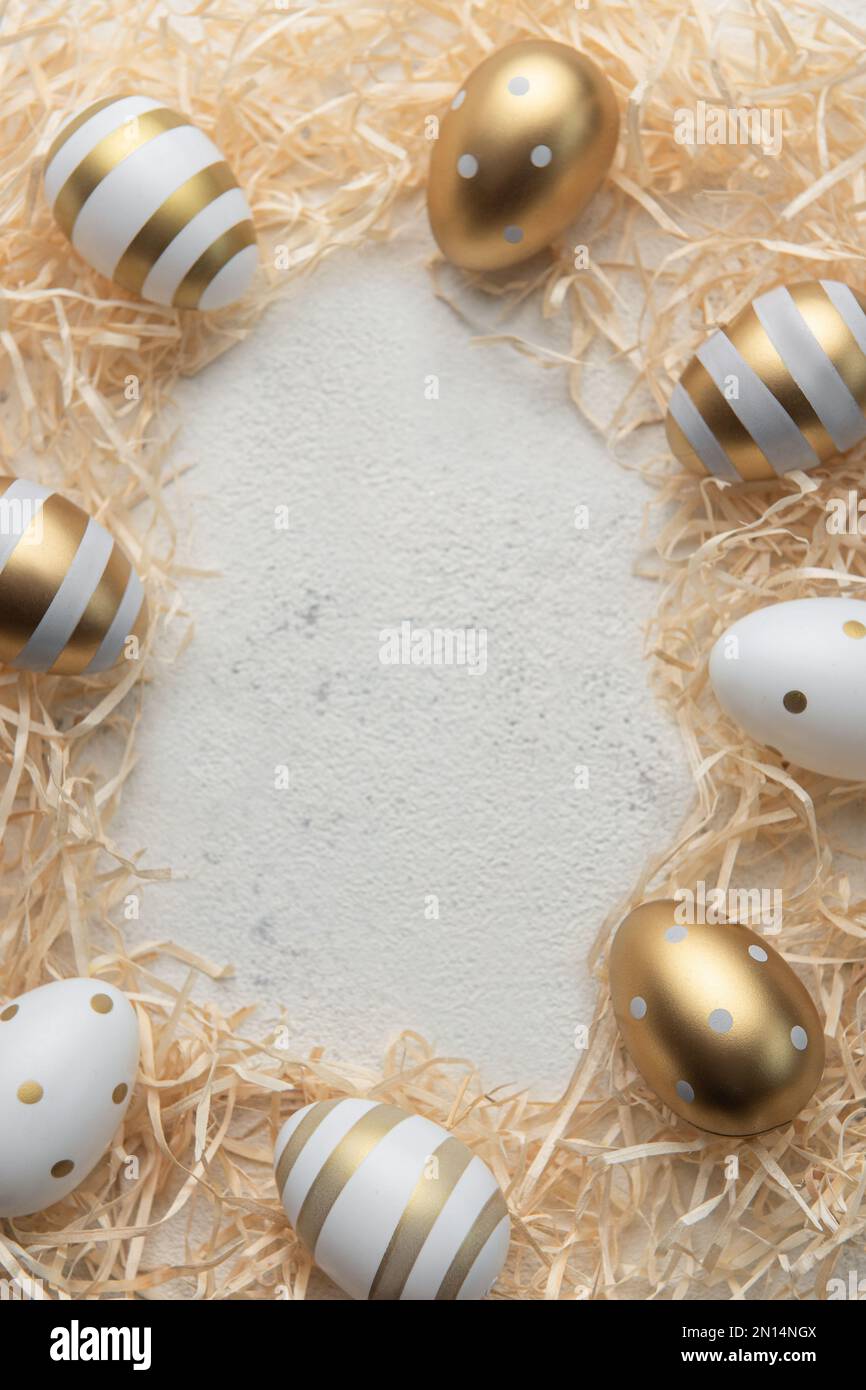 Easter eggs painted with gold paint on a straw background. Concept of ...