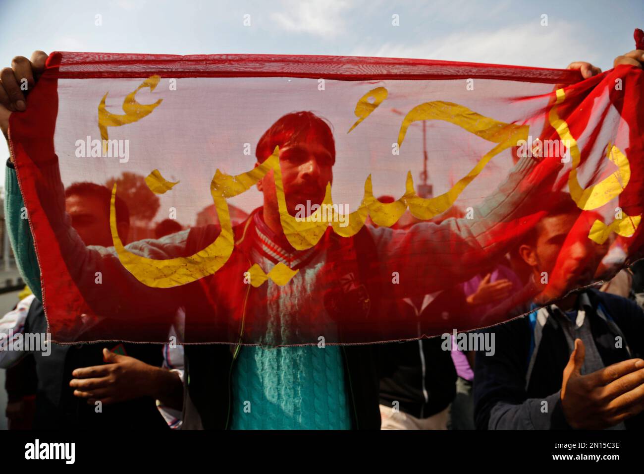 A Kashmiri Shiite Muslim holds a cloth with a religious symbol in a ...