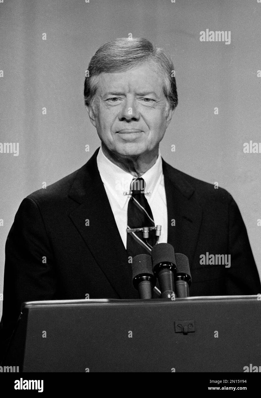 President Jimmy Carter stands behind his podium and listens as his
