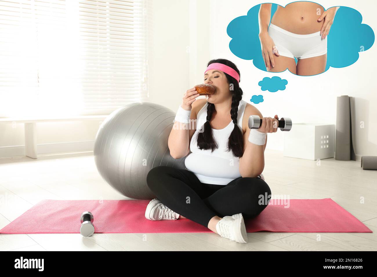 Overweight woman dreaming about slim body while pretending to do exercises and eating bun. Weight loss concept Stock Photo