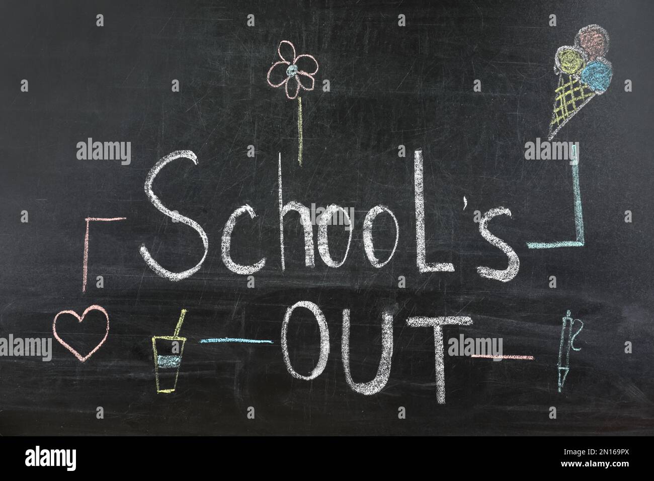 Pieces of color chalk and stationery on table near blackboard with text  School's Out. Summer holidays Stock Photo - Alamy