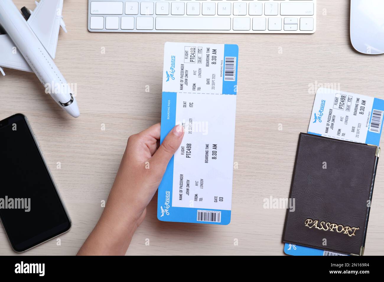 Woman holding ticket at table, top view. Travel agency concept Stock Photo