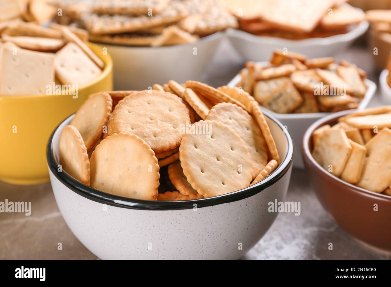 Delicious crackers in bowls on table, closeup Stock Photo