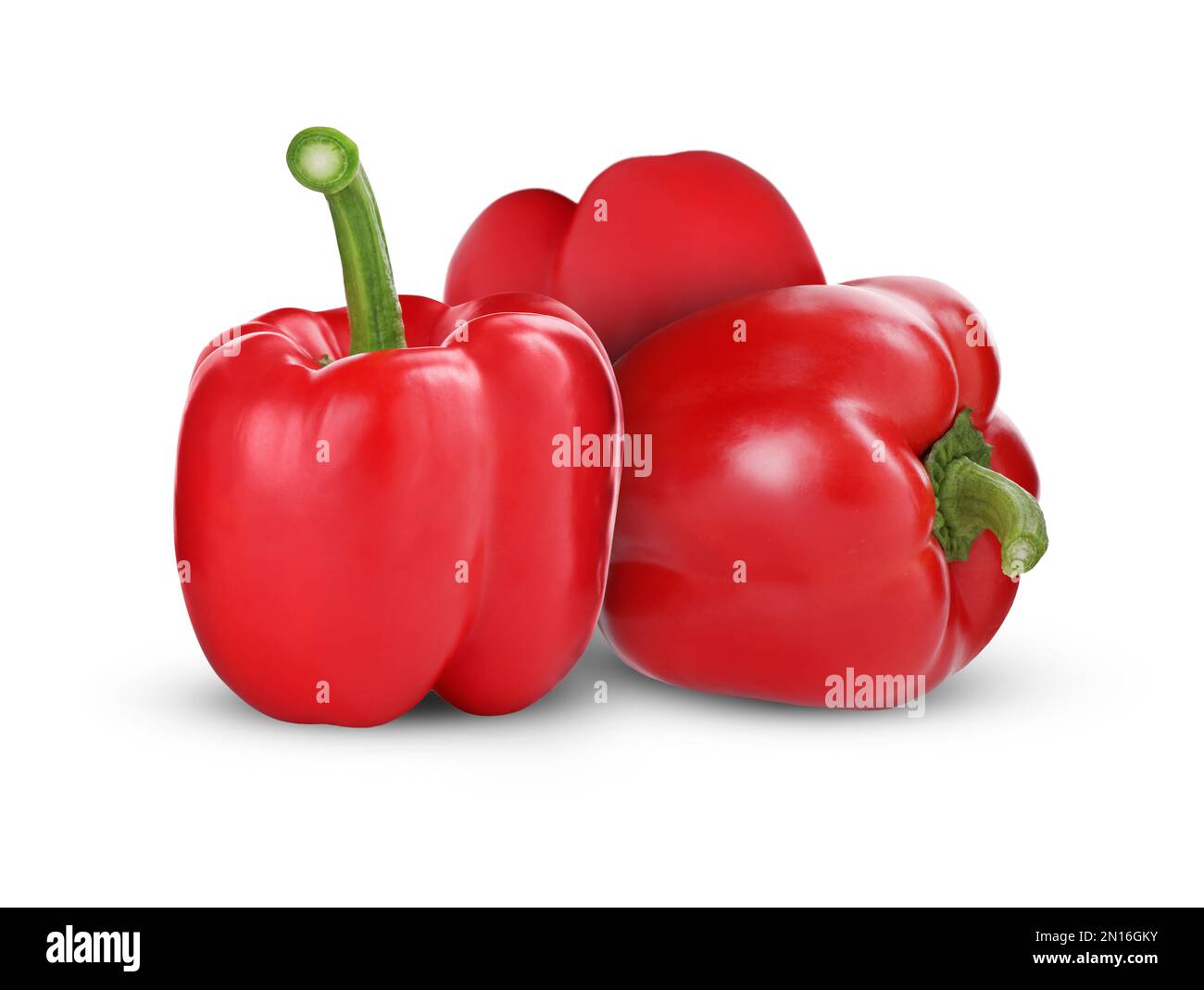 Three whole red bell peppers on white background Stock Photo - Alamy