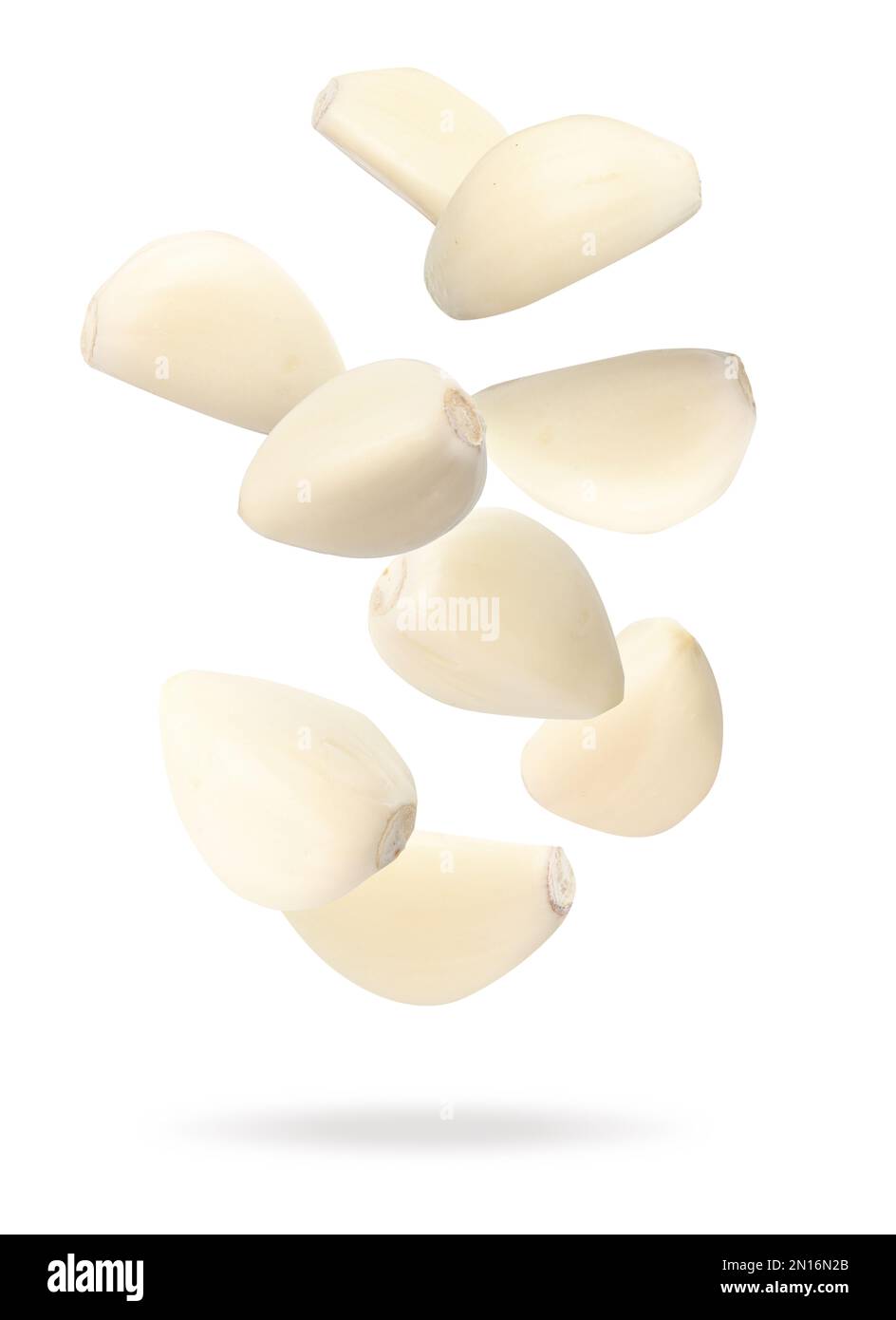 Many garlic cloves falling on white background Stock Photo - Alamy