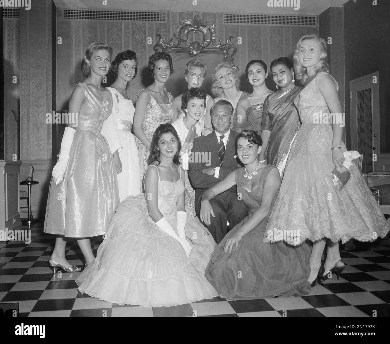 Movie star Gary Cooper is surrounded by contestants of the Miss Universe beauty pageant at a press reception in New York, July 9, 1957. Foreground, from left: Miss Cuba, María Rosa Gamio Fernández; Miss Canada, Gloria Noakes; Miss Morocco, Jacqueline Dorella Bonilla. Standing rear, from left: Miss Germany, Gerti Daub; Miss France, Lisa Simon; Miss Iceland, Bryndis Schram; Miss Sweden, Inger Jonsson; Miss England, Sonia Hamilton; Miss Israel, Atara Barzilay and Miss Austria, Hannerl Melcher. (AP Photo/Marty Lederhandler) Stock Photo