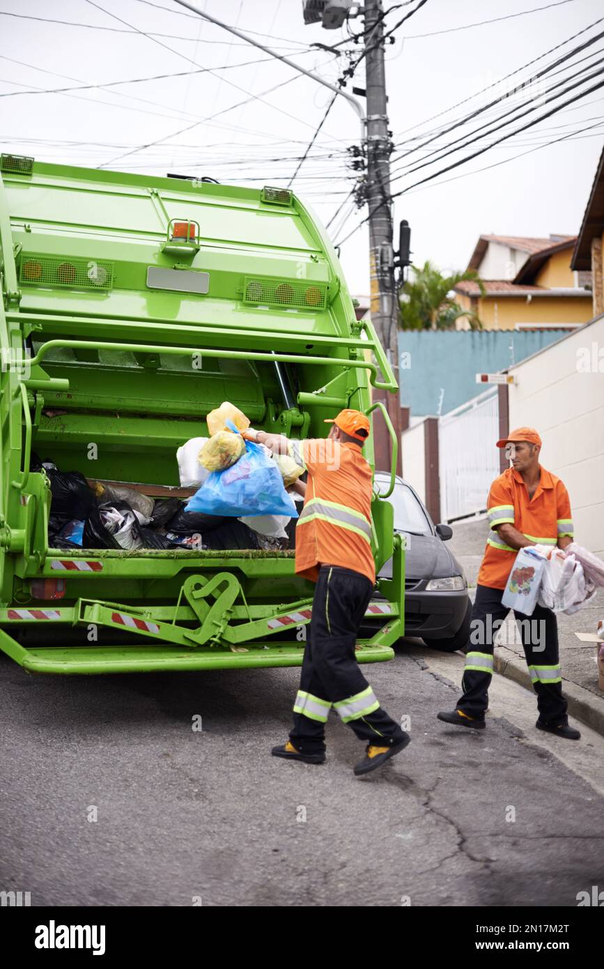 Garbage collection day again. a garbage collection team at work Stock ...