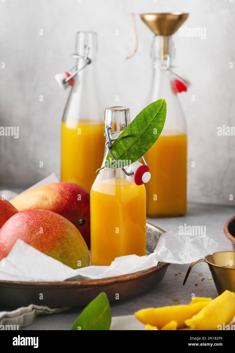 https://c8.alamy.com/comp/2N182F9/fresh-homemade-mango-juice-in-a-glass-bottle-with-fresh-ripe-fruit-and-leaves-vegan-summer-drink-concept-selective-focus-2N182F9.jpg