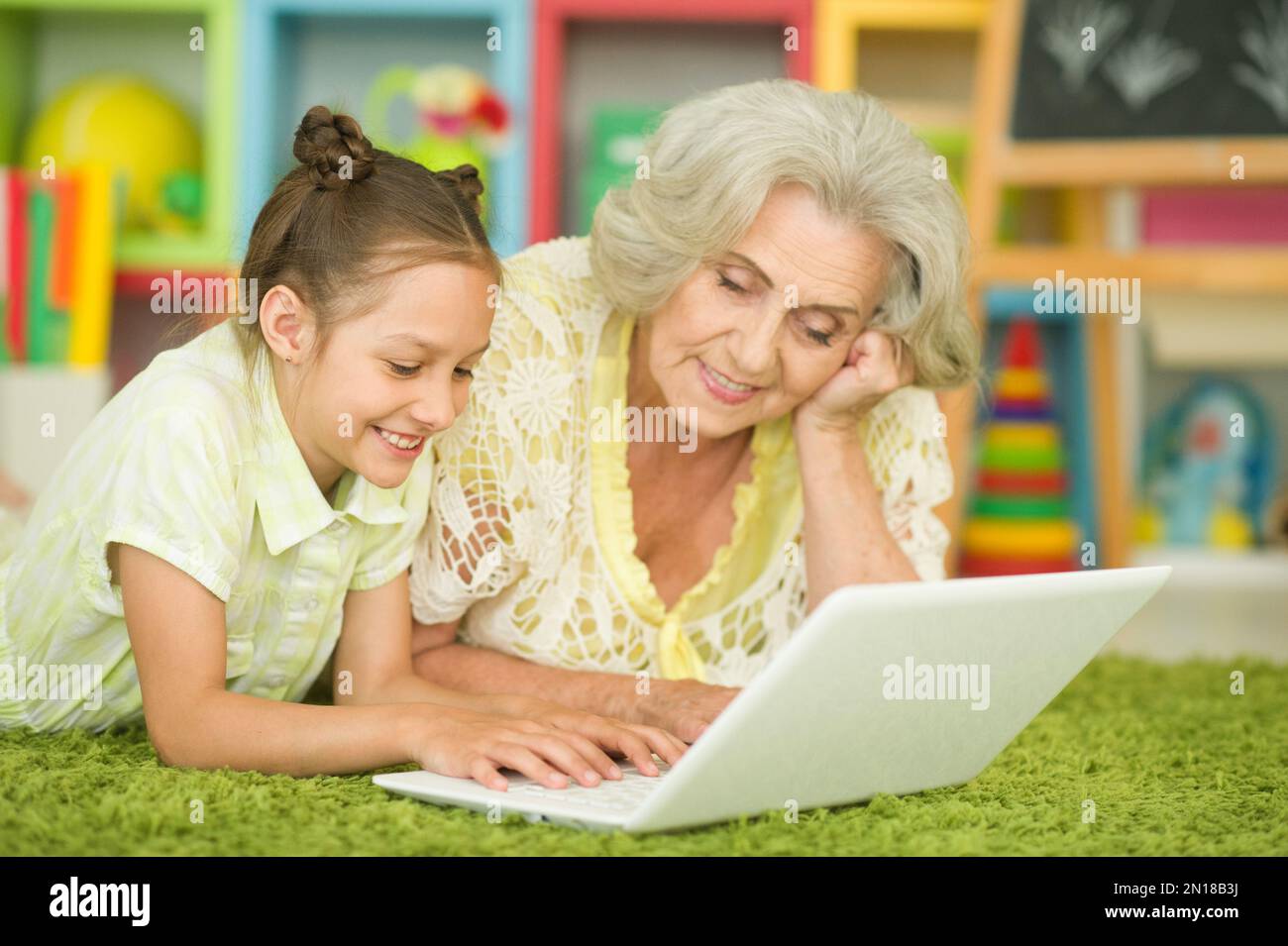 happy grandmother and granddaughter using laptop Stock Photo - Alamy