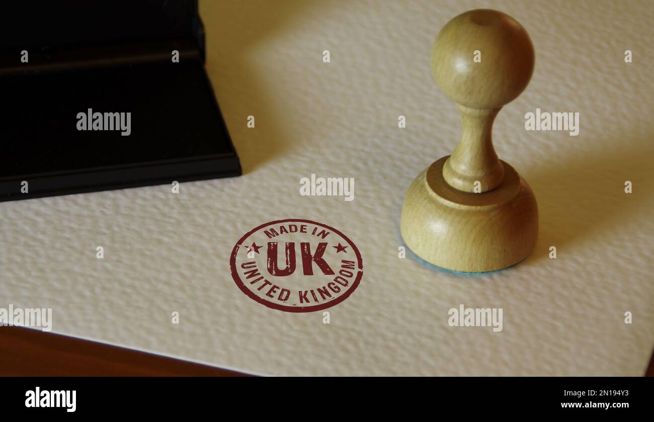 Made in UK stamp and stamping hand. Factory, manufacturing and production country concept. Stock Photo