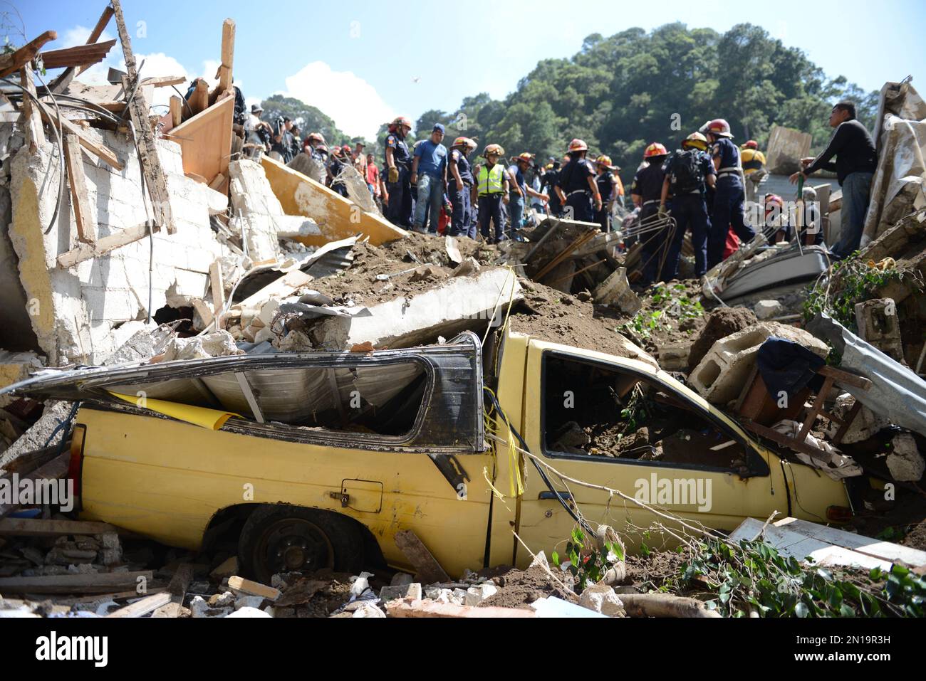 A vehicle sits crushed by debris caused by a landslide in Cambray, a