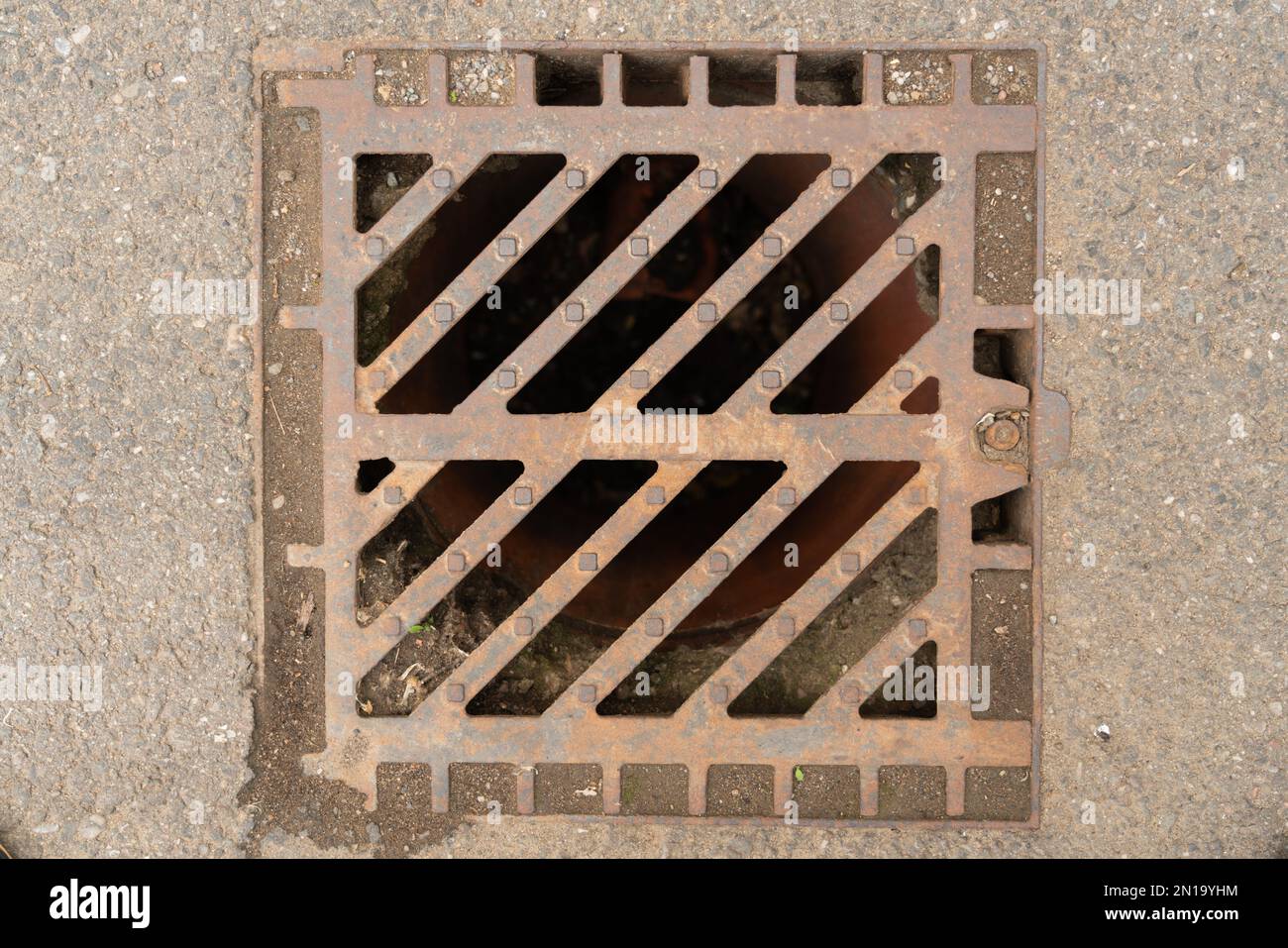 Closeup of sewer drain grate manhole made of steel metal on asphalt