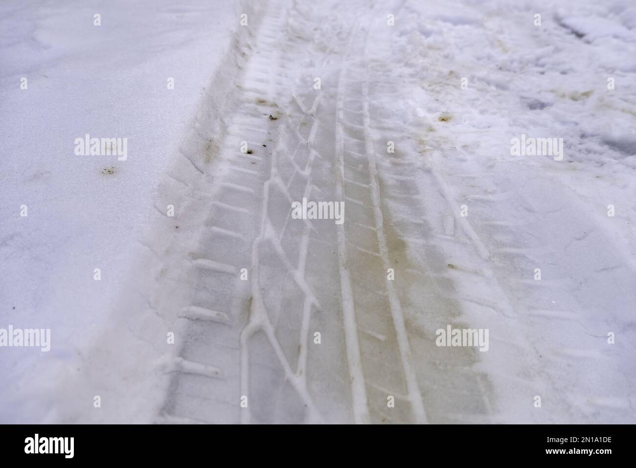 Detail of car wheel signs on a snowy road in winter Stock Photo