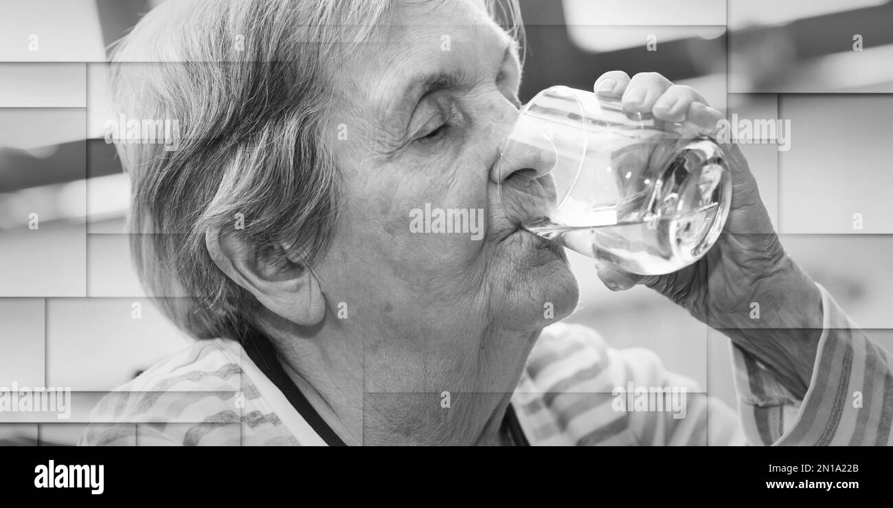 Elderly woman drinking water at home, geometric pattern Stock Photo