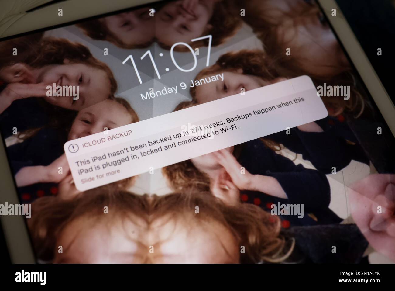Apple devices with warning about backing up the software displayed on the screen in London, UK. Stock Photo