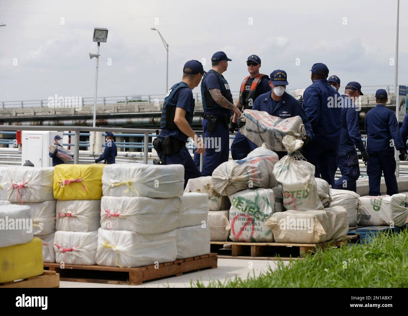U.S. Coast guardsmen offload bales of cocaine and marijuana as part of ...