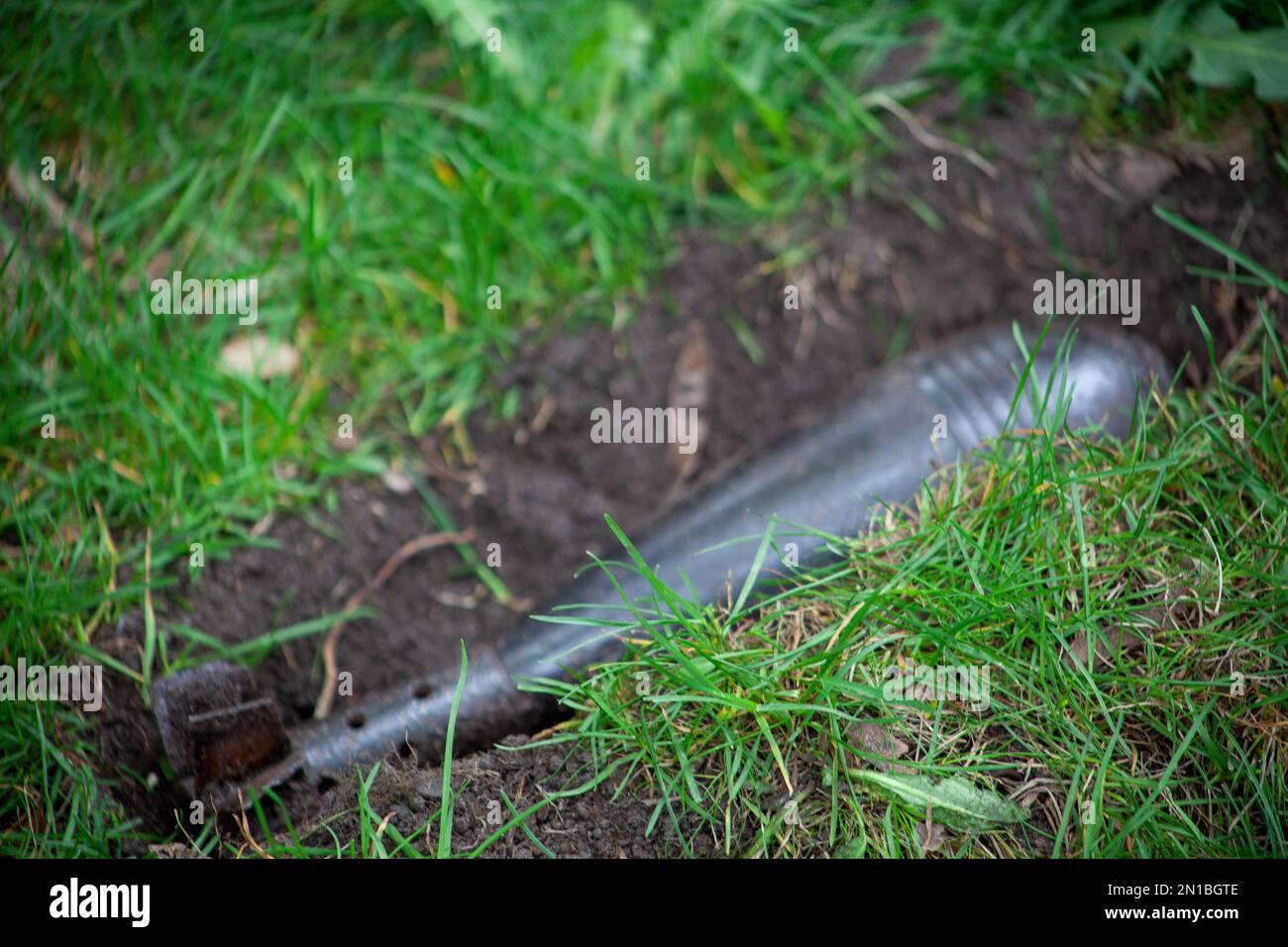 Rocket bomb lies buried in the green grass. Weapons of mass destruction