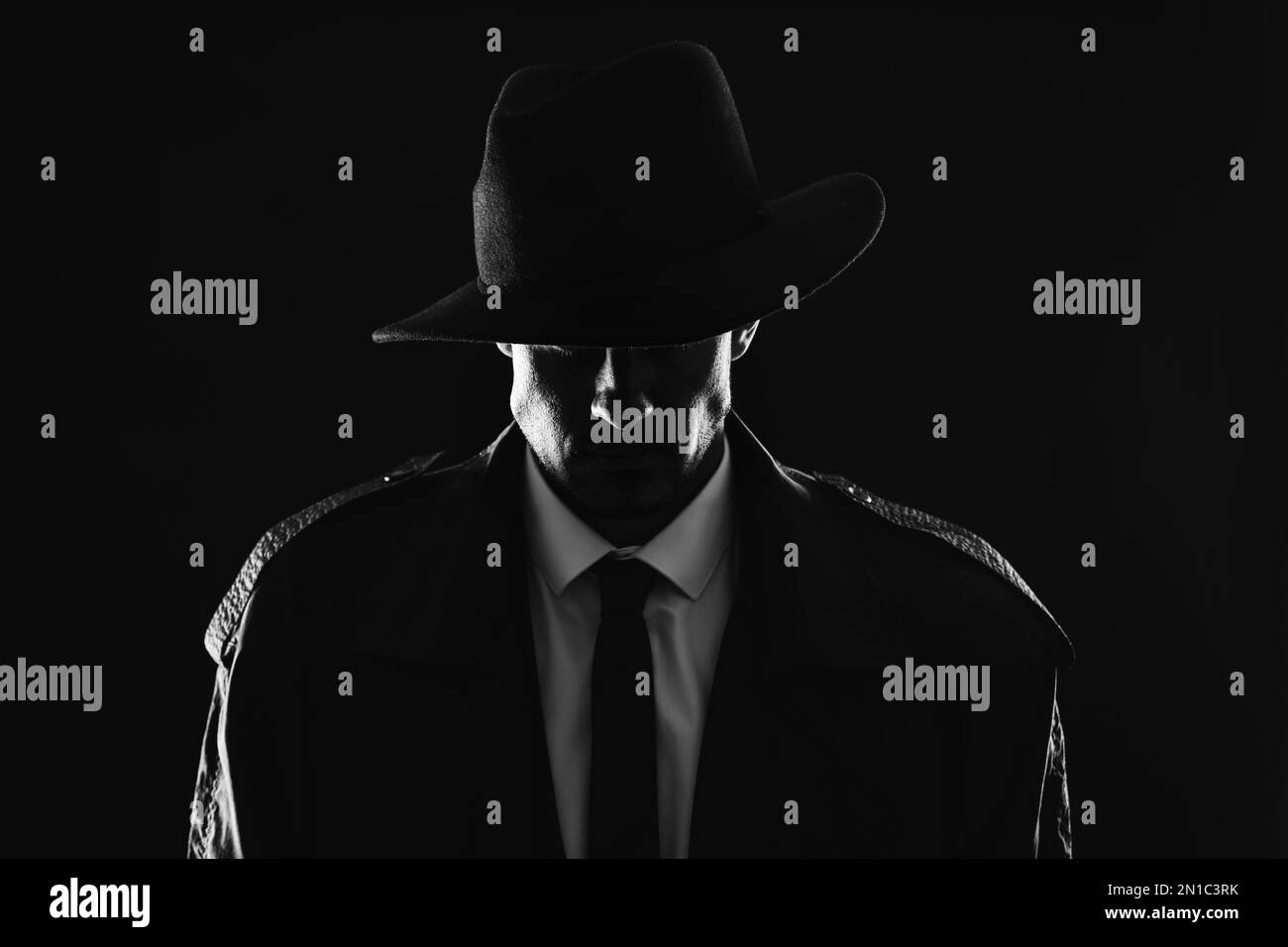 Old fashioned detective in hat on dark background, black and white ...