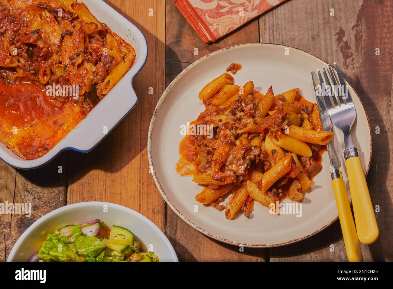Top view of minced beef pasta bake with salad. Stock Photo