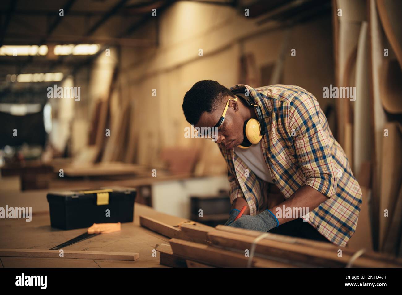 Carpenter man attend to making masterpiece woodworks handcrafted furniture fine measure in wood workshop. Stock Photo